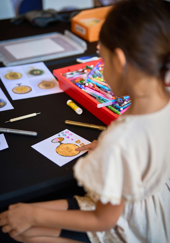 Un enfant en train de faire l'atelier Ornementation de montre